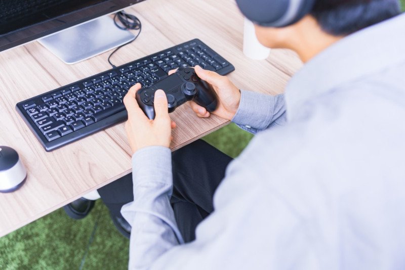 ゲームコントローラーを持つ人物のイメージ