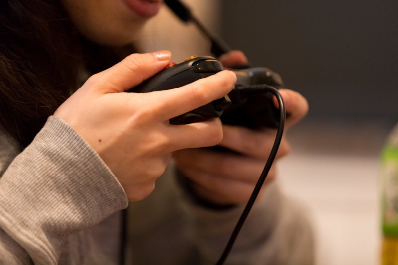 ゲームコントローラーを持つ手元の画像