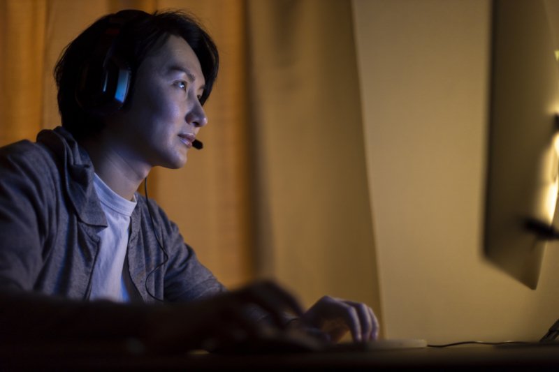 ヘッドセットをしてPCを操作する男性のイメージ