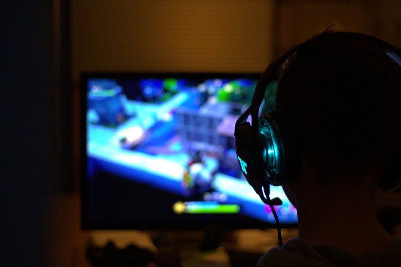 PCの画面とそれを見つめるヘッドホンをした人物