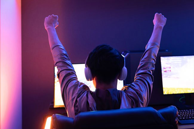 モニターの前で喜ぶ男性のイメージ