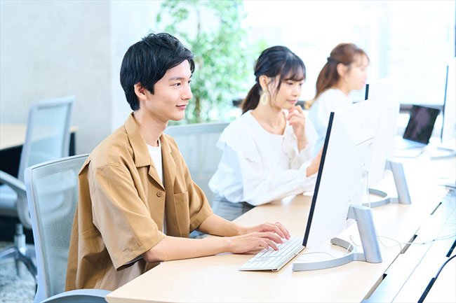 モニターを見てキーボードを打つ男性
