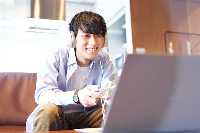 ノートパソコンでゲームを楽しむ男性のイメージ